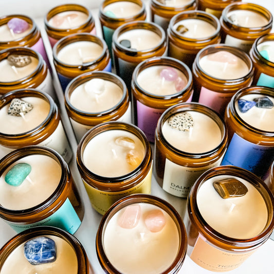 assorted 8oz crystal soy candles for energy cleansing, intentions and protection. They are poured in an amber jar with cotton wick with colorful boho labels.